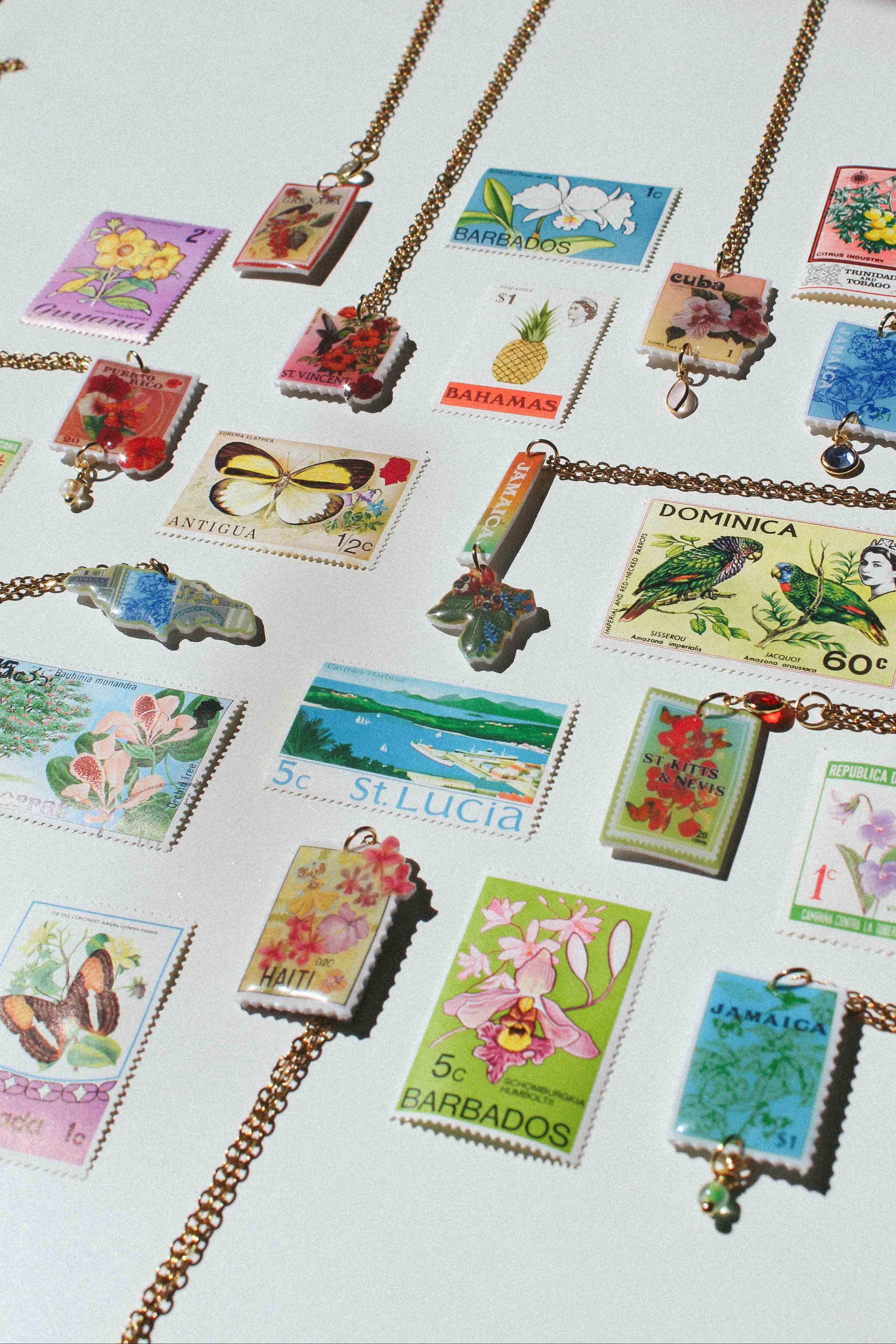 Necklaces with stamp pendants on a white surface